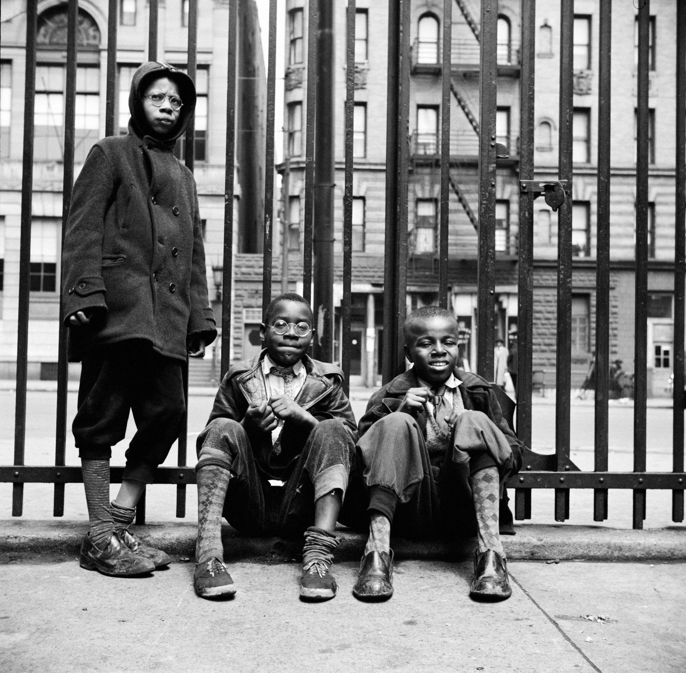 Three boys at an iron fence in Harlem, 1943, photographed by Gordon Parks